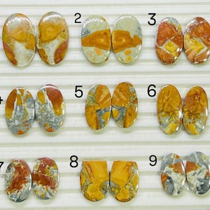 May include: Nine pairs of oval gemstones with distinctive patterns and colours. The stones display a mix of orange, yellow, grey, and white hues. Each pair is shown side-by-side, highlighting the variations in colour and veining.
