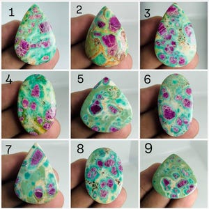 Puede incluir: Una colección de nueve piedras preciosas pulidas, cada una con una mezcla vibrante de inclusiones de color rosa magenta incrustadas en una matriz de color verde claro y crema. Las piedras tienen formas de cabujón de lágrima y ovaladas, numeradas del uno al nueve.