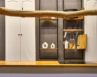 May include: A horizontal light brown driftwood pendant light fixture suspended above a wooden countertop. The natural wood branch features integrated recessed lighting elements along its length, showcasing a raw, organic texture and form.