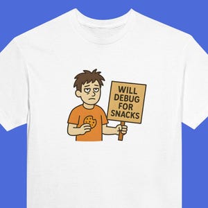May include: White t-shirt featuring a cartoon illustration of a person holding a cookie and a sign that reads "WILL DEBUG FOR SNACKS". The person is wearing an orange shirt. The design is printed on the front of the tee.