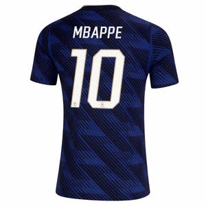 May include: A navy blue soccer jersey with the name "MBAPPE" and the number "10" in white. The jersey has a subtle diagonal stripe pattern and a white collar.