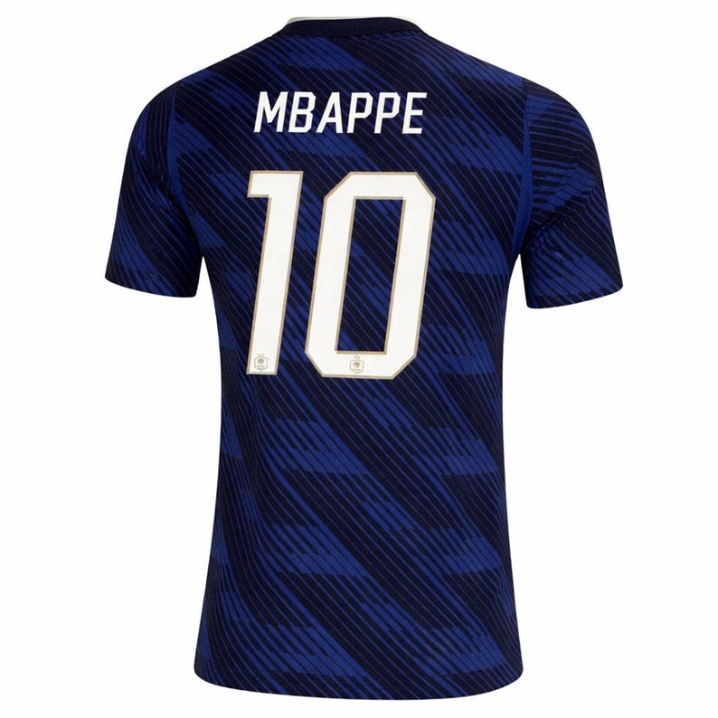 May include: A navy blue soccer jersey with the name "MBAPPE" and the number "10" in white. The jersey has a subtle diagonal stripe pattern and a white collar.