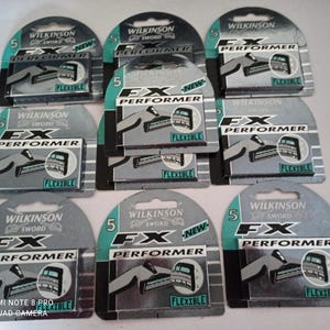 May include: A collection of Wilkinson Sword FX Performer razor blade cartridges. Each package is gray and teal, with the brand name and product details printed on the front. The packaging indicates the blades are flexible.