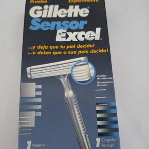 May include: A Gillette Sensor Excel razor and refill pack. The packaging is primarily blue and white, with the brand name and product details prominently displayed. The razor has a silver handle and a white head with multiple blades.