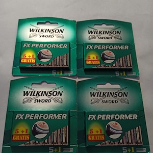 May include: Four green and white Wilkinson Sword FX Performer razor blade packages. Each package displays the brand name, product name, and a graphic of the blades. The text "5+1 Gratis" is also visible on each package.