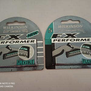 May include: Two packages of Wilkinson Sword FX Performer razor blades. Each package has a teal and gray design with the word "FLEXIBLE" and the number "5". The packaging also includes the text "NEW".