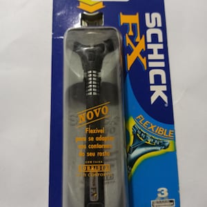 Pode incluir: Uma lâmina de barbear flexível Schick FX na embalagem original. A lâmina é preta e prateada, com o nome da marca e os detalhes do produto impressos na embalagem. A embalagem é azul e amarela.