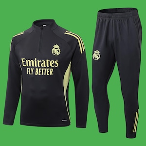 May include: Black athletic tracksuit with gold accents. The top features a half-zip, the text "Emirates FLY BETTER", and a team crest. The matching pants have a team crest and gold stripes. The tracksuit is on a green background.
