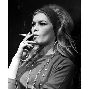 May include: Black and white photograph of a woman smoking a cigarette. She wears a dark headband, a button-down sweater, and a long necklace. The image includes the text "8X10" / 16X20" and "20X25 cm / 40X50 cm".