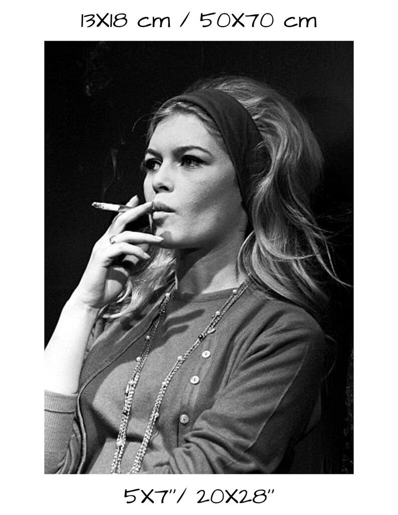 May include: Black and white photograph of a woman smoking a cigarette. She wears a dark headband, a button-down cardigan, and a long beaded necklace. The image is a portrait, with the woman's face in profile. The print size is 5x7 inches and 20x28 inches.