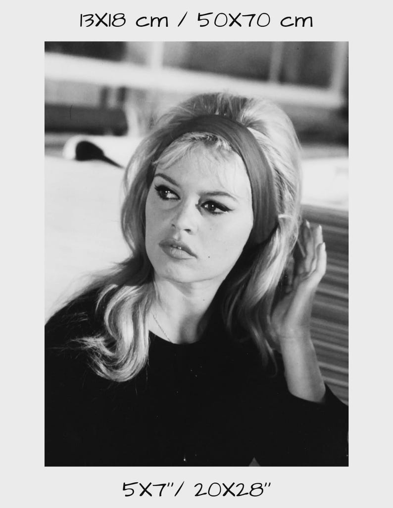 May include: Black and white photograph of a woman with blonde hair wearing a dark top and a headband. The image includes the text "13X18 cm / 50X70 cm" and "5x7" / 20x28".