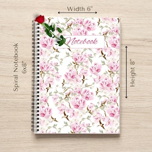Może przedstawiać: Spiralny notatnik, około 15 x 20 cm, z kwiatowym wzorem różowych piwonii na białym tle. Słowo "Notebook" jest napisane na różowo. Czerwona róża i zielone liście zdobią oprawę.