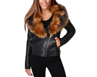 May include: Black leather jacket with a faux fur collar in shades of brown and tan. The jacket features a gold zipper and a classic biker style. The model is wearing black pants and a black top.