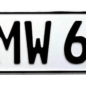 May include: A rectangular German license plate with a white background and black lettering. The plate features the letters "B MW 6220" and a blue section with the letter "D" and a circle of yellow stars. There are also two round stickers.