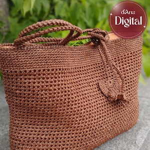May include: A brown crocheted tote bag featuring a textured stitch pattern, two braided handles, and a decorative crocheted tassel hanging from the side. The interior is lined with a light peach fabric, and the bag has a rectangular shape.
