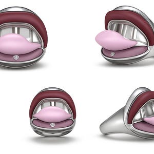 May include: A silver ring with a unique design, featuring a mouth shape with a maroon upper lip, a pink tongue, and a pink lower lip. The ring has a small, round, clear gem on the lower lip.