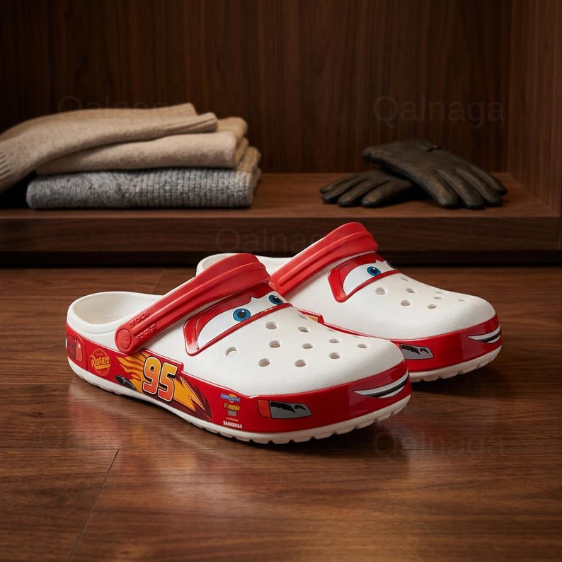 Puede incluir: Zuecos blancos y rojos con tem&aacute;tica de Cars con un dise&ntilde;o de cara de dibujos animados. Los zuecos presentan el n&uacute;mero 95 y otros gr&aacute;ficos en el lateral. Los zapatos est&aacute;n hechos de un material ligero y tienen una correa para un ajuste seguro.