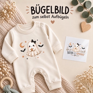 Könnte beinhalten: Ein cremefarbener Baby-Strampler mit langen Ärmeln und einem Aufdruck eines Geistes mit schwarzer Schleife, der einen Stern hält, umgeben von Fledermäusen, Monden und Sternen. Daneben liegt eine Karte mit dem Motiv und dem Text SÜSS & SPOOKY.