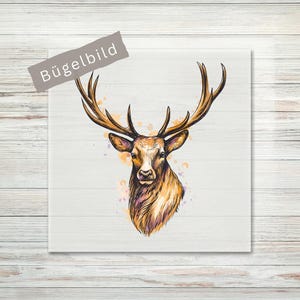 Könnte beinhalten: Ein quadratisches Bügelbild mit einer detaillierten Illustration eines Hirschkopfes mit großem Geweih. Das Motiv ist mit braunen, orangen und violetten Aquarell-Akzenten gestaltet. Der Text "BÜGELBILD" steht auf einem grauen, diagonalen Banner.