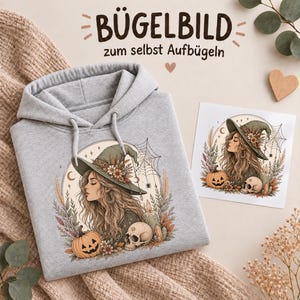 Könnte beinhalten: Ein hellgrauer Kapuzenpullover mit einem Aufdruck einer Person mit Hexenhut, umgeben von einem Kürbis, einem Totenkopf und Spinnweben. Neben dem Pullover liegt ein quadratischer Transferbogen mit demselben Motiv und dem Text BÜGELBILD.