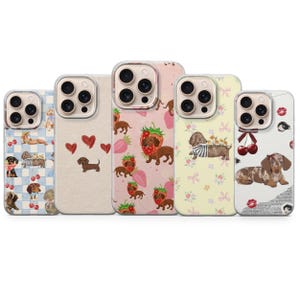 Könnte beinhalten: Fünf Handyhüllen mit Dackel-Designs. Die Hüllen zeigen Muster aus Erdbeeren, Herzen, Kirschen und Dackeln. Die Farbpalette umfasst Rosa, Gelb und Blau, wobei die Dackel in verschiedenen Farben gehalten sind.