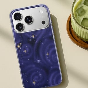 May include: A smartphone case with a dark blue galaxy design featuring swirling patterns and gold and white stars. The case has a clear border and a camera module with three lenses.