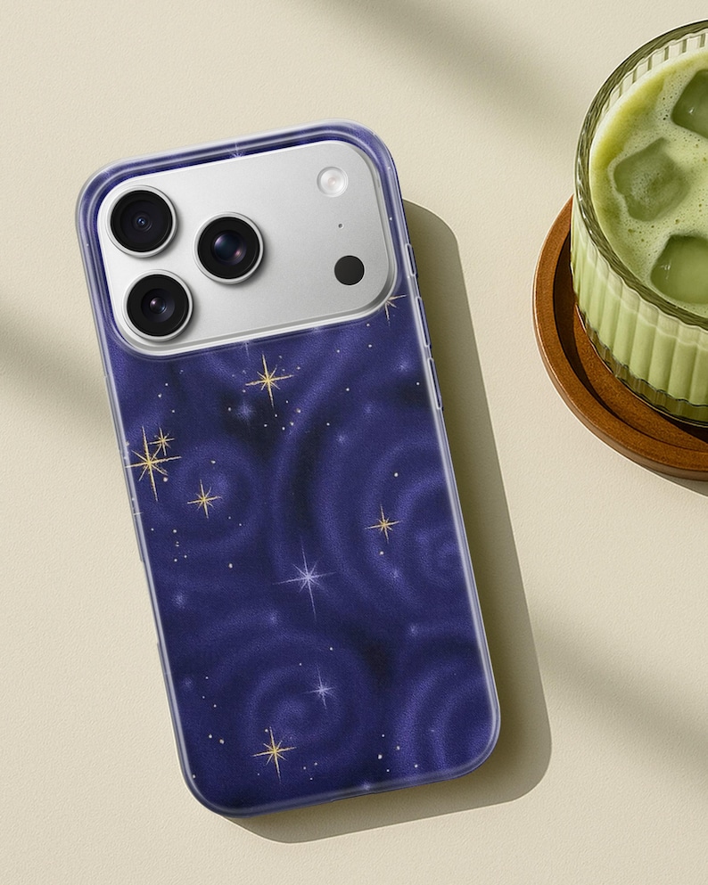 May include: A smartphone case with a dark blue galaxy design featuring swirling patterns and gold and white stars. The case has a clear border and a camera module with three lenses.
