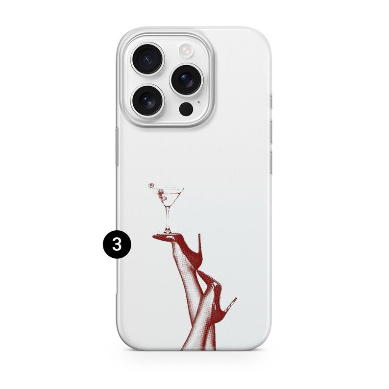 Puede incluir: Funda de tel&eacute;fono blanca con una ilustraci&oacute;n roja de una copa de c&oacute;ctel sostenida por piernas con tacones altos rojos. La funda tiene un borde transparente y un recorte para c&aacute;mara de tres lentes.
