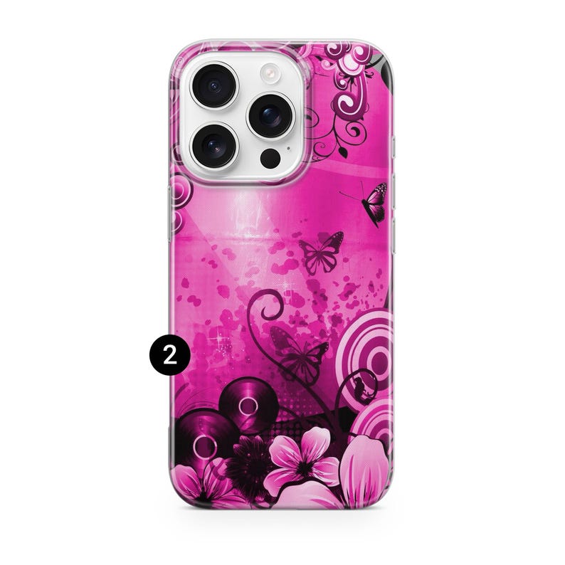 May include: A pink phone case with a floral and butterfly design. The case features a vibrant pink background with black and white floral accents, butterflies, and circular patterns. The number "2" is visible on the case.