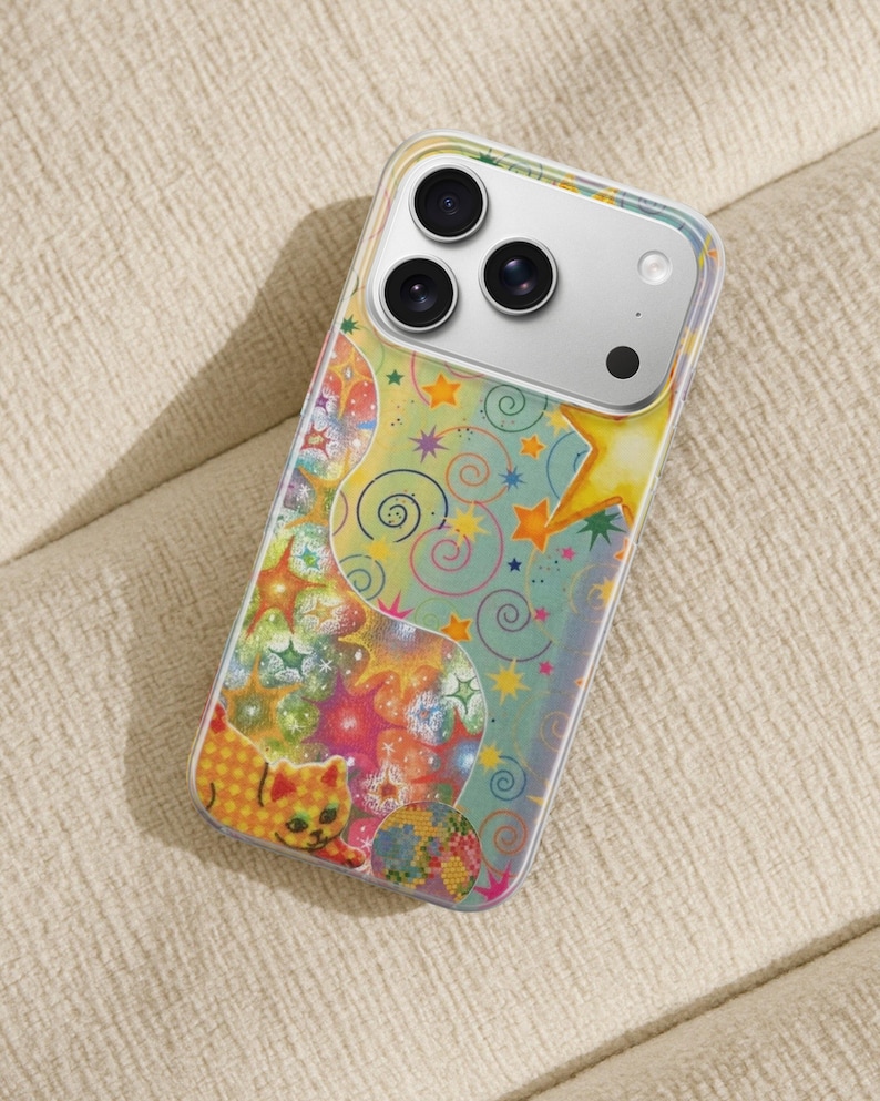 May include: A clear phone case with a colorful, whimsical design. The case features a pattern of stars, swirls, and a cartoon cat in shades of yellow, orange, pink, and blue. The phone's camera lenses are visible.