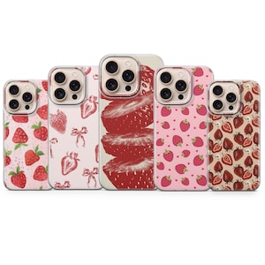 May include: Five smartphone cases featuring strawberry-themed designs. The cases display various patterns including whole strawberries, sliced strawberries, and small bows on light pink, cream, and solid red backgrounds with camera cutouts.
