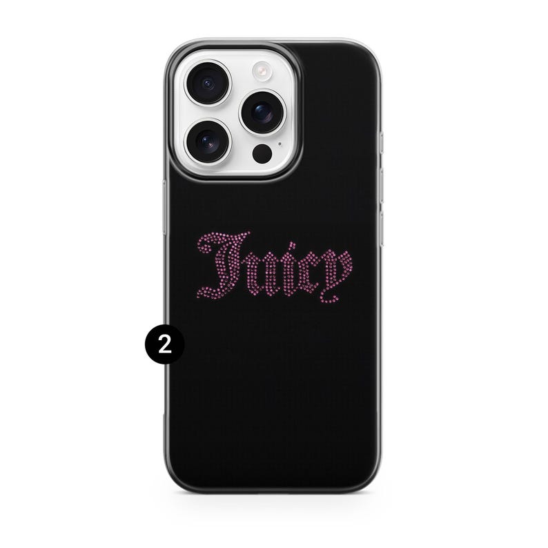 May include: Black phone case with a clear border. The case features the word "Juicy" in pink rhinestones. The phone case has a camera and flash.