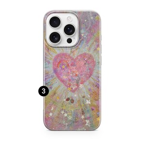 May include: A phone case with a colorful, abstract design. The case features a large pink heart in the center, surrounded by a burst of light and stars. The background has a mix of pastel colors, including pink, yellow, and blue.