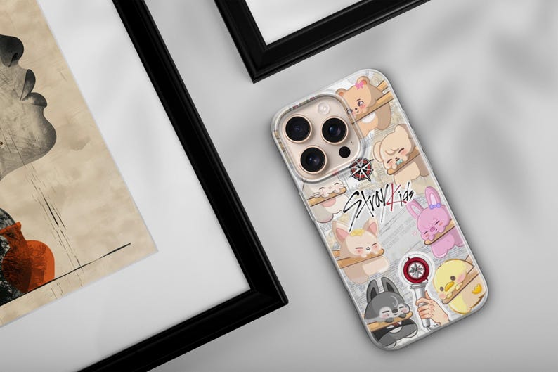 May include: A phone case with a design featuring cartoon animals and the text "Stray Kids". The case has a clear background with various cartoon characters, including bears, bunnies, and a wolf. The case is on a white surface.