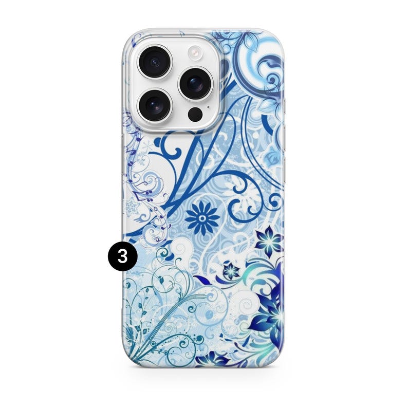 May include: A clear phone case with a blue floral design. The case features a pattern of swirling vines, flowers, and leaves in shades of blue and white. The phone case has a camera cutout and the number "3" in a black circle.