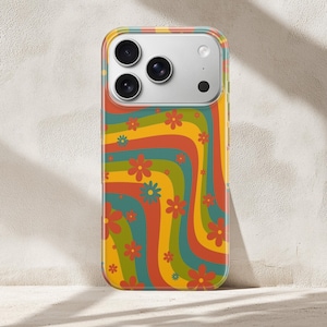 Pode incluir: Uma capa de telefone colorida com um design floral retr&ocirc;. A capa apresenta um padr&atilde;o ondulado de listras laranja, amarelas, verdes e azuis, adornado com pequenas flores vermelhas e azuis. A capa foi projetada para caber em um smartphone com um conjunto de c&acirc;meras.