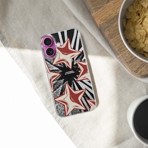 May include: A clear smartphone case featuring a graphic design of red and cream-colored stars over a black and white sunburst pattern. The text "CHANGE IS COMING" is printed in the center. The case has a purple camera lens frame and clear edges.