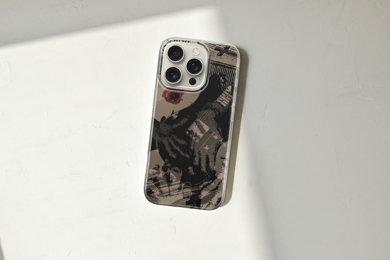 May include: Clear phone case with a printed design. The design features a black and tan graphic with a red floral accent. The case has a clear border and covers the phone's back and sides, with cutouts for the camera and buttons.