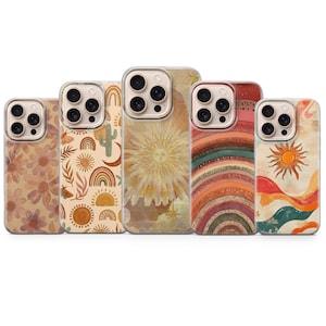 Könnte beinhalten: Fünf Handyhüllen mit farbenfrohen, böhmischen Designs. Die Hüllen zeigen florale, Regenbogen-, Sonnen- und Wüstenmuster in Braun-, Orange- und Gelbtönen. Jede Hülle hat einen transparenten Rand und einen Kameraausschnitt.