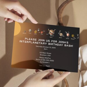May include: A black and orange invitation card with a solar system graphic. The card reads "PLEASE JOIN US FOR JOSH'S INTERPLANETARY BIRTHDAY BASH!" with event details. The card is held by two hands.