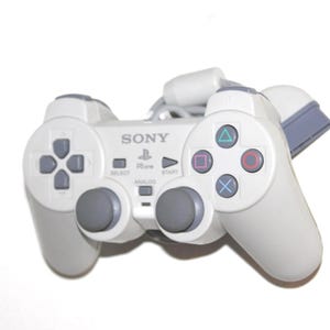 May include: A light gray Sony PlayStation controller with a cord. The controller has a directional pad, buttons with colored symbols, and two analog sticks. The word "SONY" is printed on the controller.