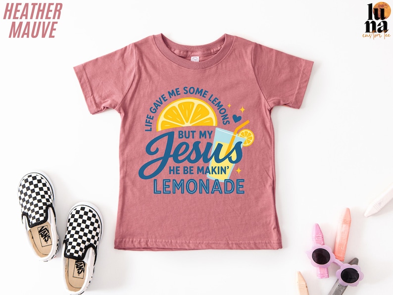 a pink t-shirt with a colorful graphic design, a pair of black and white checkered shoes, and some children's sunglasses.