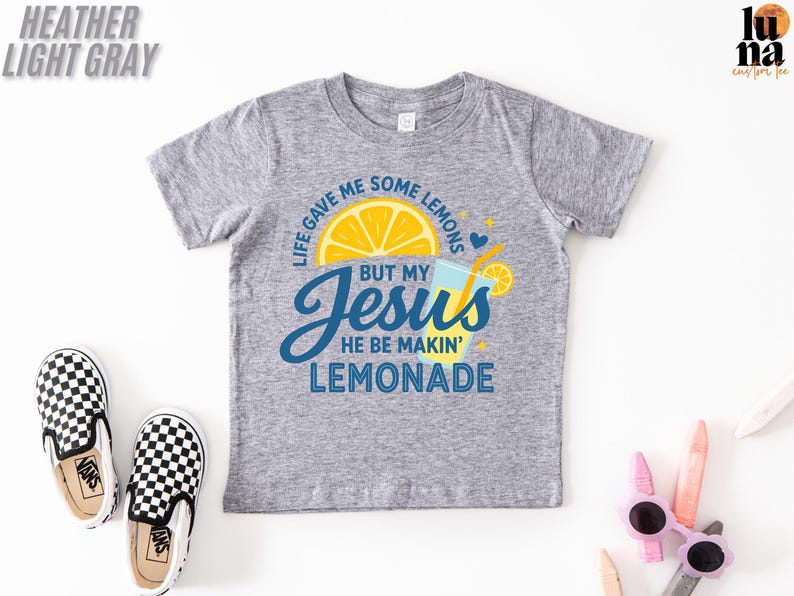 A gray t-shirt with a graphic design, a pair of black and white checkered shoes, and some children's sunglasses on a white background.