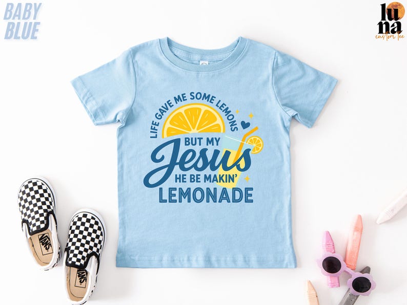 A light blue t-shirt with a graphic design and text, along with a pair of black and white checkered shoes, a pair of sunglasses, and some other objects on a white background.