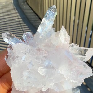 May include: A cluster of clear, translucent quartz crystals with sharp, pointed terminations and multifaceted surfaces. The mineral formation features a bright, icy white appearance with varying degrees of transparency and natural geometric facets.