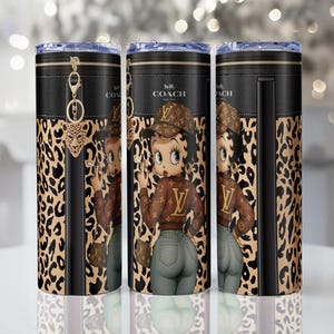 May include: Three stainless steel tumblers with a black leather-like top and leopard print design. Each tumbler features a cartoon image of Betty Boop wearing a brown jacket and hat with the Louis Vuitton logo. The tumblers have a Coach logo.