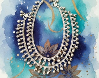 May include: Silver anklet with small bells and chain links. The anklet is displayed on a watercolor background of blue and teal hues, with gold accents and floral designs.