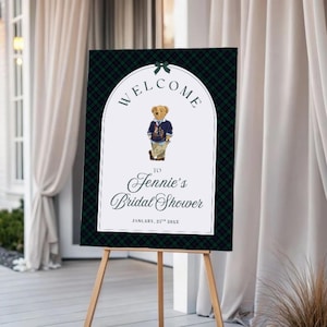 Puede incluir: Un letrero de bienvenida para la despedida de soltera de Jennie. El letrero presenta un fondo a cuadros verdes y negros. El texto "WELCOME" está sobre una ilustración de un oso de peluche. Las palabras "to Jennie's Bridal Shower" están debajo.