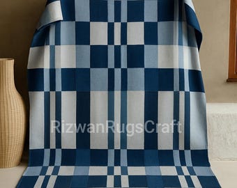 May include: A rectangular throw blanket featuring a geometric grid pattern in shades of navy blue, light blue, and white. The design consists of alternating vertical and horizontal blocks of varying sizes. The text RizwanRugsCraft is visible.