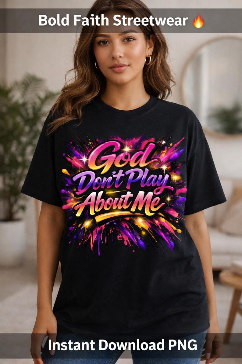 May include: Black t-shirt with the text "God Don't Play About Me" in a colorful, stylized design. The shirt features a vibrant explosion of pink, purple, yellow, and orange colors. The words "Bold Faith Streetwear" are at the top.